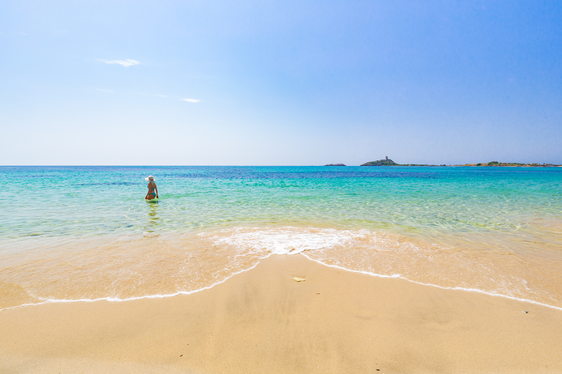 Spiaggia Su Guventeddu a Pula con sabbia bianca finissima e acque color smeraldo, ideale per famiglie.